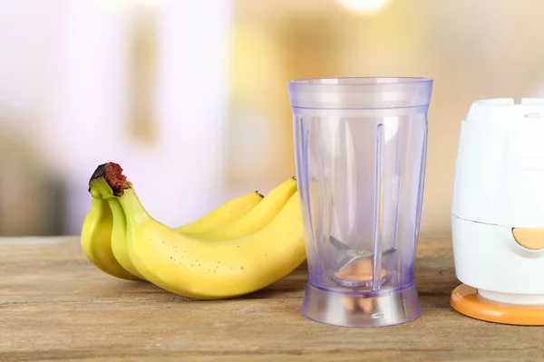 Pisang dan blender di meja kayu, di latar belakang cerah — Stok Foto