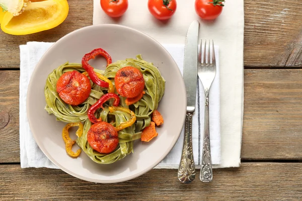 Sabrosa pasta con pimienta, zanahoria y tomates sobre fondo de mesa de madera —  Fotos de Stock