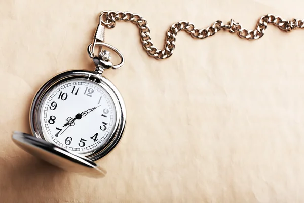 Silver pocket clock on old paper background — Stock Photo, Image