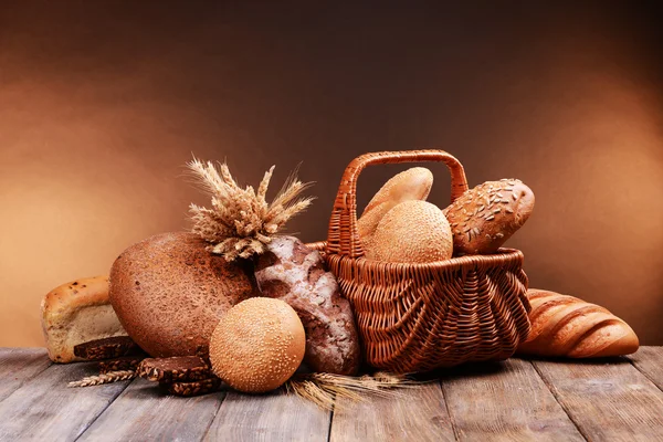 Different bread on table on brown background — Stock Photo, Image