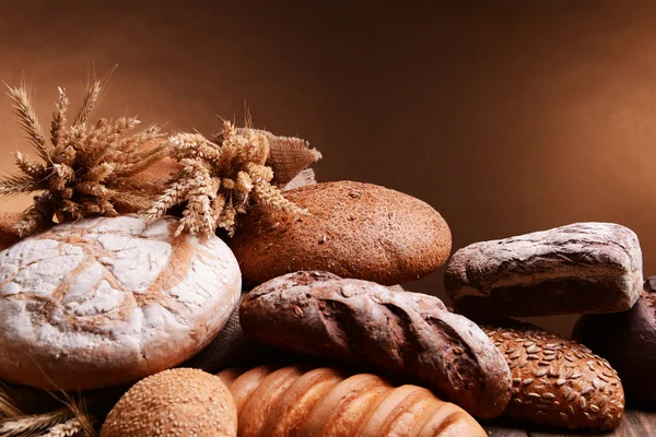 Pane diverso sul tavolo su sfondo marrone — Foto Stock