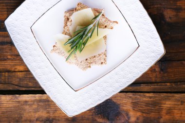 Parmesan peyniri dilimleri ince dal biberiye ahşap masa arka plan üzerinde plaka üzerinde ile ile Crispbread