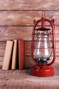 Rustik ahşap arka plan kitapları ile gaz lambası