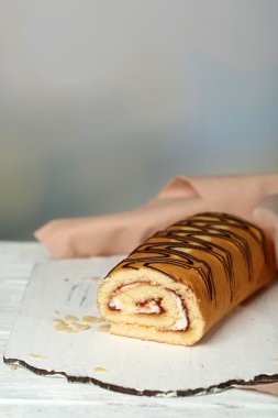 Açık renkli ahşap masaya lezzetli rulo pasta