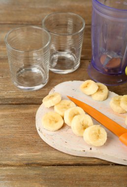 Ahşap arka plan üzerinde kesme tahtası üzerinde muz dilimlenmiş