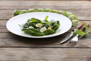 Bıldırcın yumurta ve plaka rustik ahşap masa arka plan üzerinde fesleğen salata