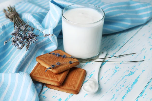 Homemade yogurt in glass and tasty cookie on wooden table background — Stock Photo, Image