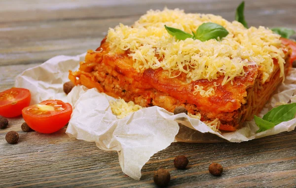 Porzione di gustose lasagne su tavola di legno — Foto Stock