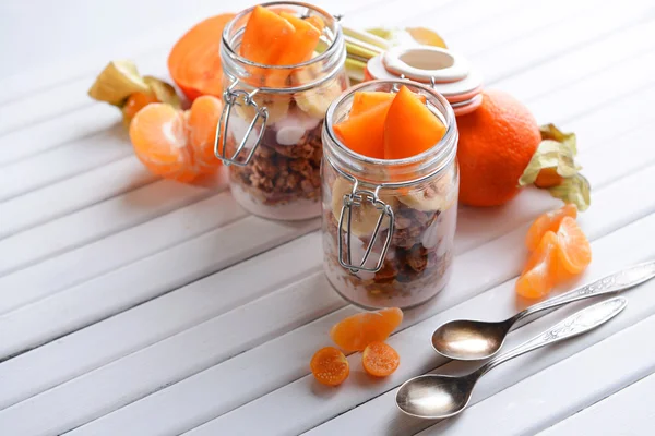 Friska skiktad dessert med müsli och frukt på bord — Stockfoto