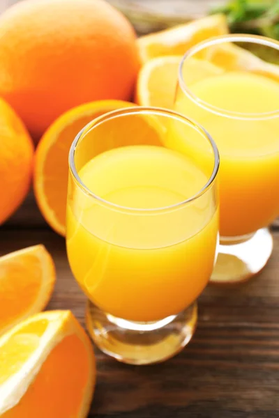 Glass of orange juice and slices on wooden table background — Stock Photo, Image