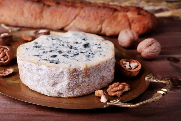 Queso azul con nueces, baguette y heno sobre bandeja metálica y fondo de mesa de madera —  Fotos de Stock