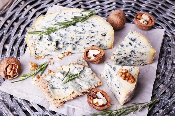 Queijo azul com raminhos de alecrim e nozes no fundo do tapete de vime — Fotografia de Stock