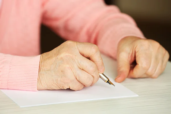 Взрослая женщина пишет ручкой — стоковое фото