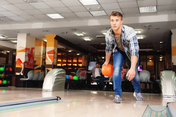 Young man playing bowling in club — Stock Photo, Image