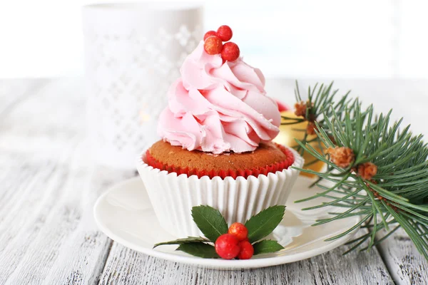 Tasse-Kuchen auf Untertasse mit Weihnachtsdekoration auf farbigem Holztischhintergrund — Stockfoto