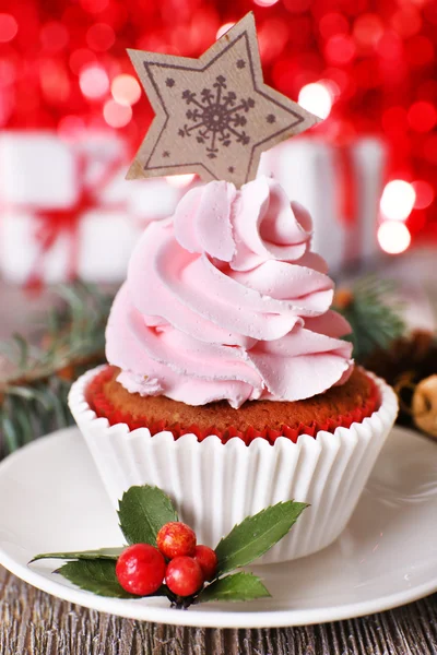 Чашка торт со сливками на блюдце и рождественские украшения на деревянном столе и ярко светить на заднем плане — стоковое фото