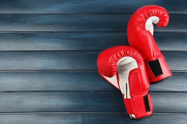 Par de guantes de boxeo sobre fondo de madera de color —  Fotos de Stock