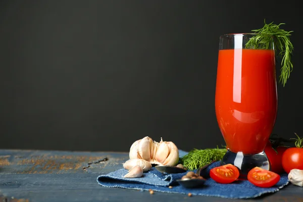 Glas leckerer Tomatensaft und frische Tomaten auf dem Tisch, auf grauem Hintergrund — Stockfoto