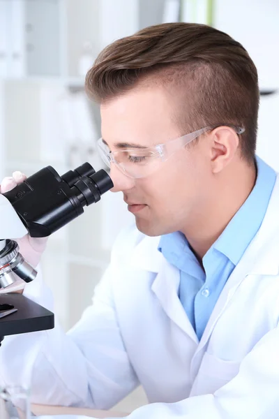 Cientista masculino usando microscópio em laboratório — Fotografia de Stock