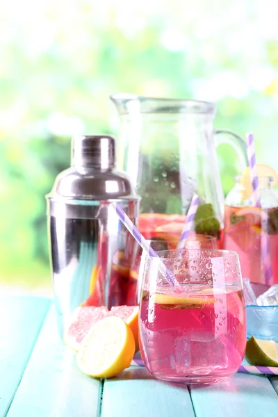 Рожевий лимонад в окулярах і глечик на столі крупним планом — стокове фото