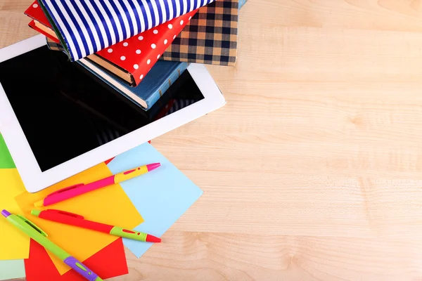 Pile of books with tablet on wooden table background — Stock Photo, Image