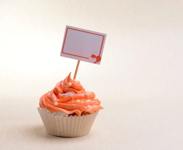 Delicioso cupcake com inscrição na mesa em fundo bege — Fotografia de Stock