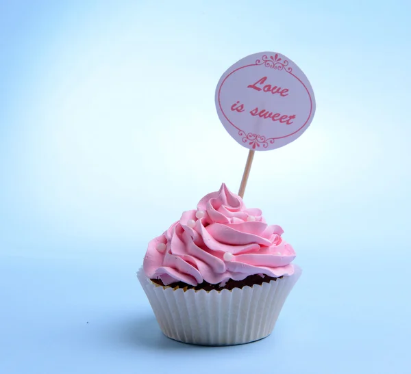 Delizioso cupcake con iscrizione sul tavolo su sfondo blu — Foto Stock