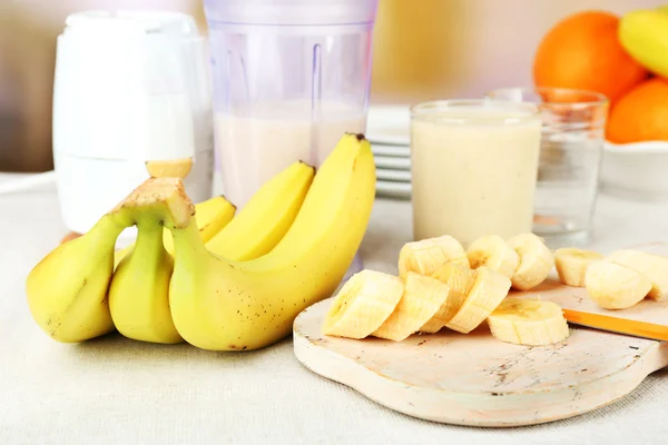 Plasterki banana na deski do krojenia, na tle drewniane — Zdjęcie stockowe