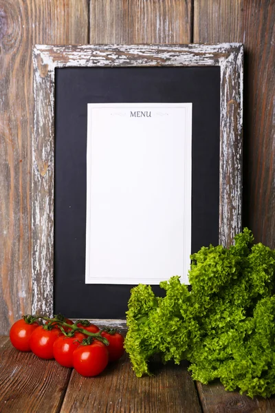 Menütafel auf rustikalem Holzplanken Hintergrund mit Kirschtomaten und Salat auf rustikalem Holzplanken Hintergrund — Stockfoto