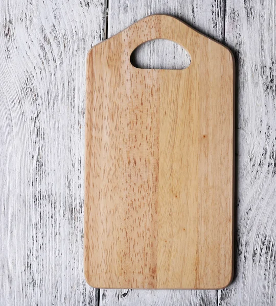 Cutting board on color wooden planks background — Stock Photo, Image