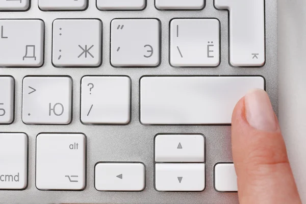 Weiblicher Finger mit Tastatur auf weißem Hintergrund — Stockfoto