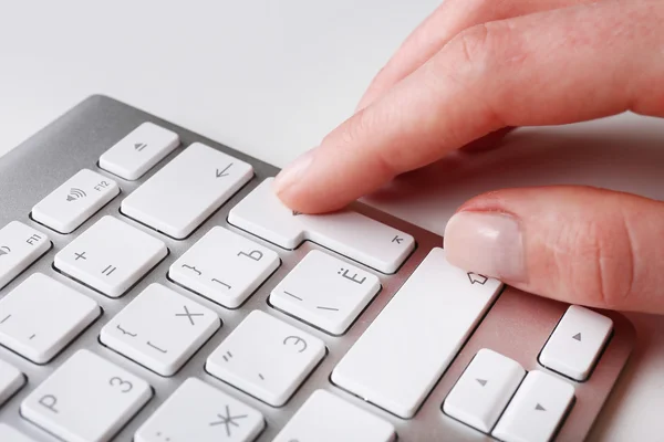 Mão feminina com teclado sobre fundo branco — Fotografia de Stock