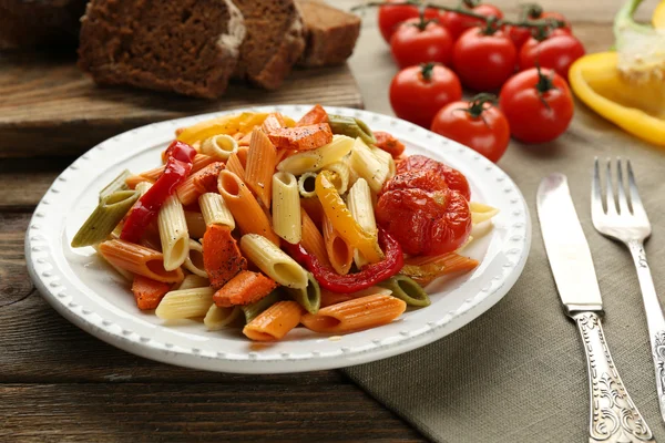 Ensalada de pasta con pimienta, zanahoria y tomates sobre fondo de mesa de madera — Foto de Stock