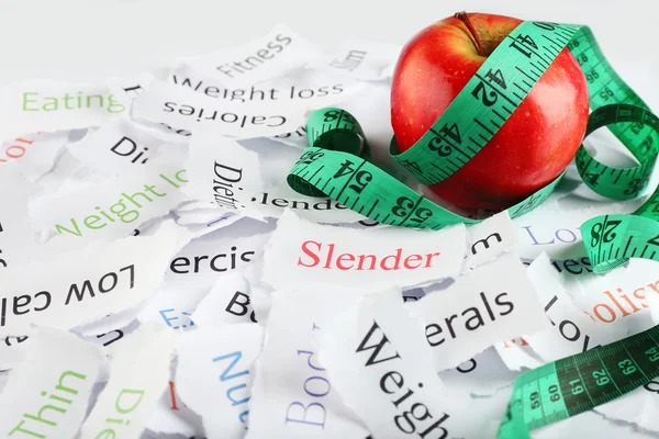 Papers with words, apple and measuring tape — Stock Photo, Image