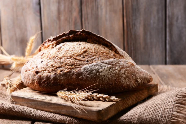 Gustoso pane sul tavolo su sfondo di legno — Foto Stock