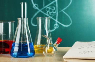 Kimya sınıfı test tüpleri üzerinde yeşil tahta arka plan ile Danışma