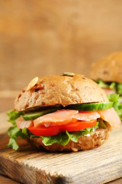 Sandviç somon ahşap arka plan üzerinde kesme tahtası üzerinde