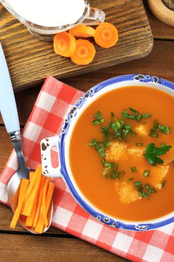 Ahşap arka plan üzerinde kapta havuç çorbası