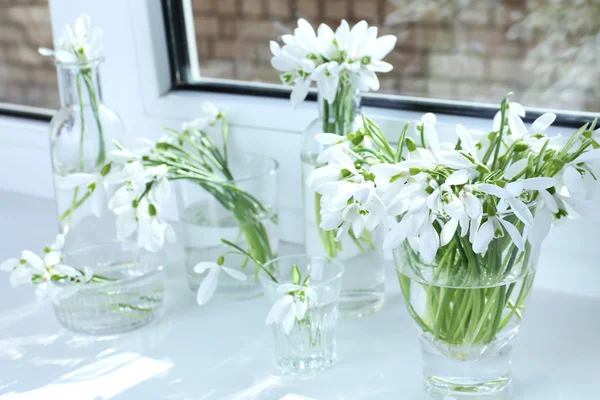 Beaux bouquets de gouttes de neige dans des vases sur le rebord de la fenêtre — Photo