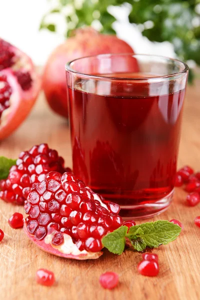 Melograni maturi con succo sul tavolo primo piano — Foto Stock