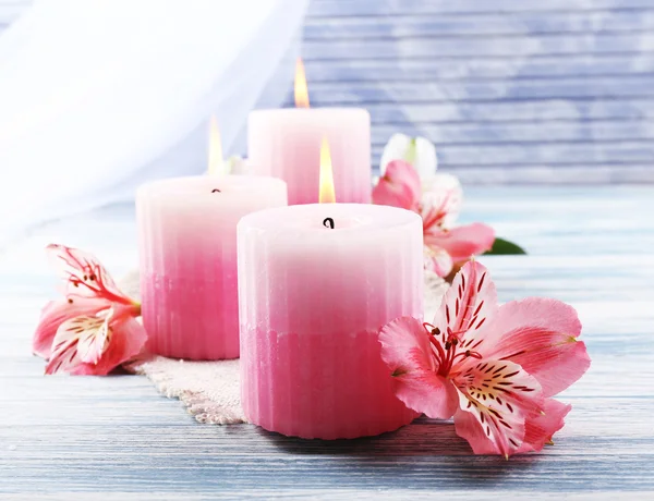 Beautiful candles with flowers on wooden background — Stock Photo, Image