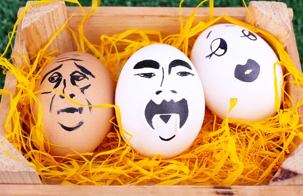 Eggs in wooden box on green background — Stock Photo, Image