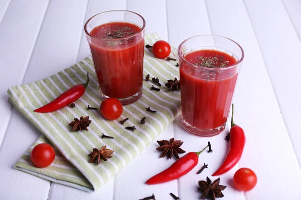 Suco de tomate em copos e legumes frescos em guardanapo em fundo de madeira — Fotografia de Stock