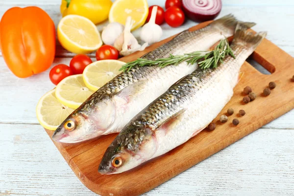 Verse rauwe vis en voedselingrediënten op tafel — Stockfoto