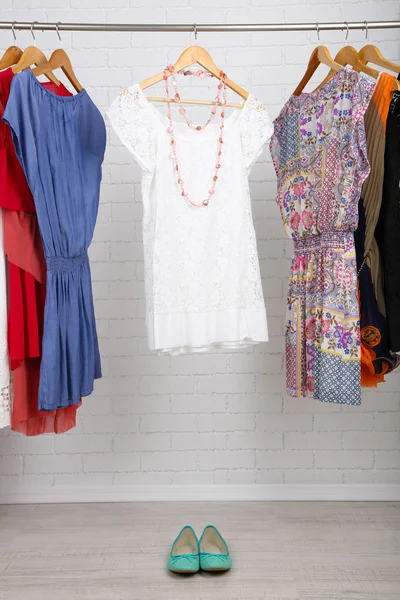 Female dresses on hangers in room — Stock Photo, Image