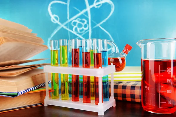 Glassware with chemical agent on desk, on green blackboard background — Stock Photo, Image