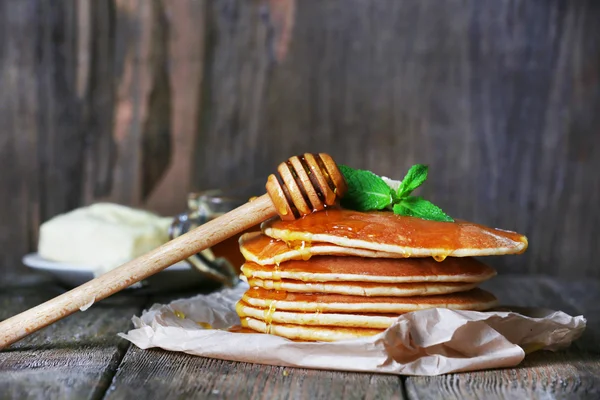 Tumpukan pancake dengan madu dan mentega pada latar belakang kayu pedesaan — Stok Foto