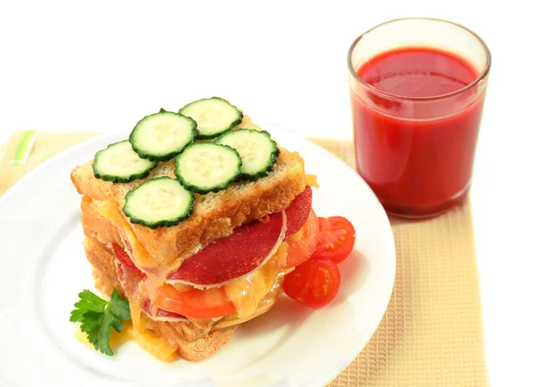 Sandwich met kaas en groenten op plaat in de buurt van glas sap geïsoleerd op wit — Stockfoto