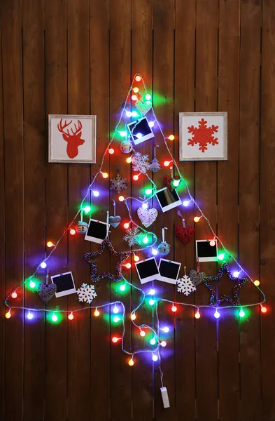 木製の壁の背景にクリスマス ツリーの形のガーランドします。 — ストック写真