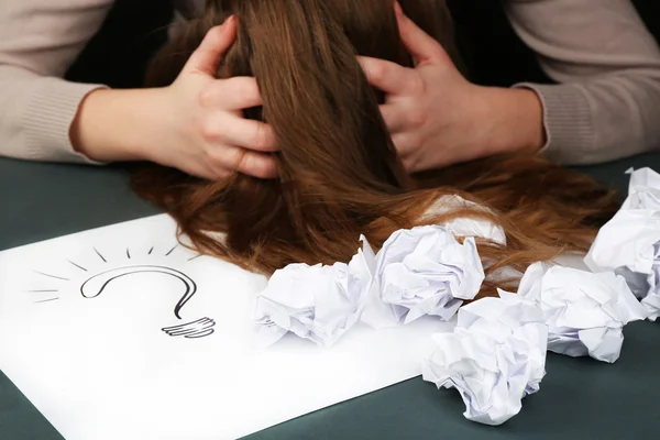 Mujer cansada en el escritorio con signo de interrogación hoja de papel, sobre fondo oscuro — Foto de Stock